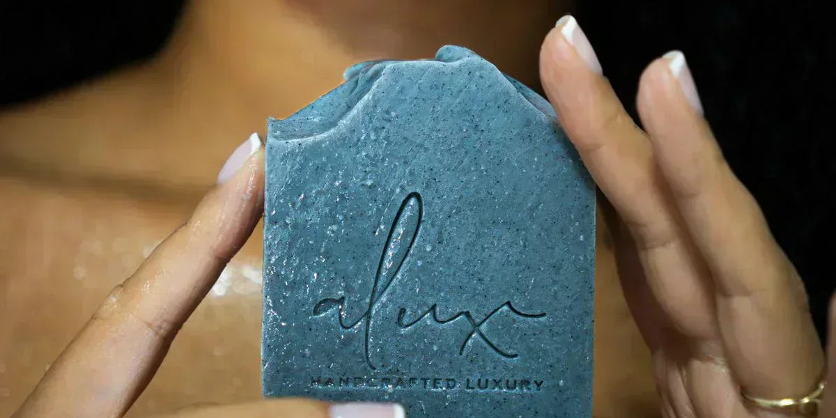 Model using Alux Cosmetics Activated Charcoal Soap for healthy, clear skin.